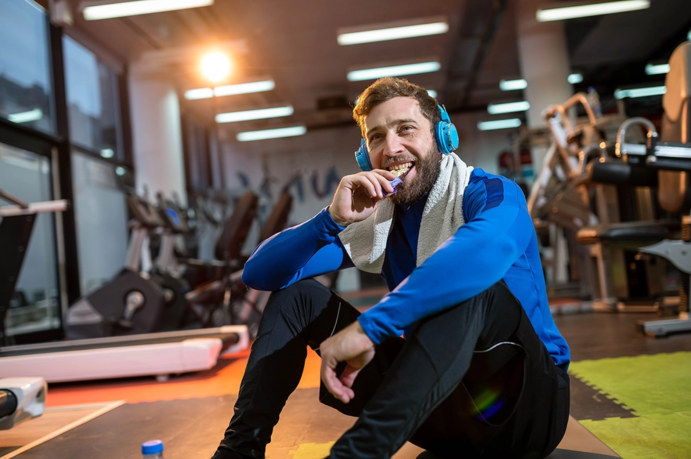 Post workout men in gym eating snack